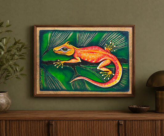 Reptilla Vulgaris Rex printable wall art, created from an original hand-painted artwork by MatiArtBox, displayed in a dark wood frame on an olive-green wall above a wooden cabinet.