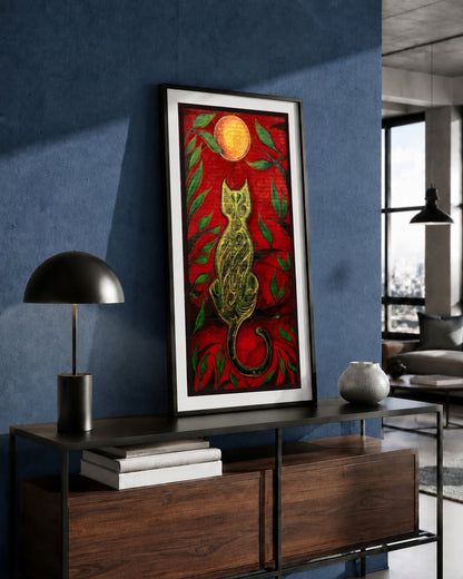 The Green Cat and the Golden Moon artwork by MatiArtBox displayed in a black frame above a wooden console against a deep blue wall in a modern interior.