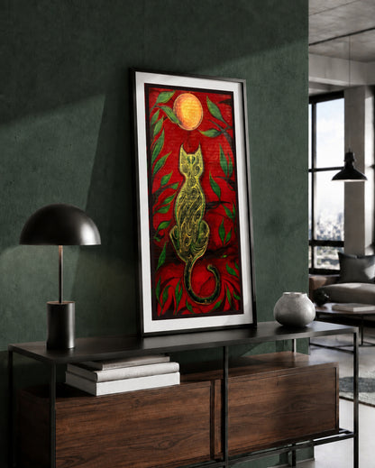 The Green Cat and the Golden Moon artwork by MatiArtBox displayed in a black frame above a wooden console against a dark green wall in a modern interior.